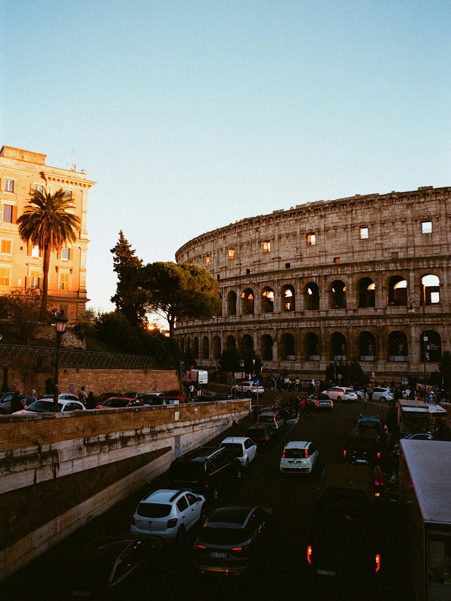 The Colosseum at dusk, traffic in the street below